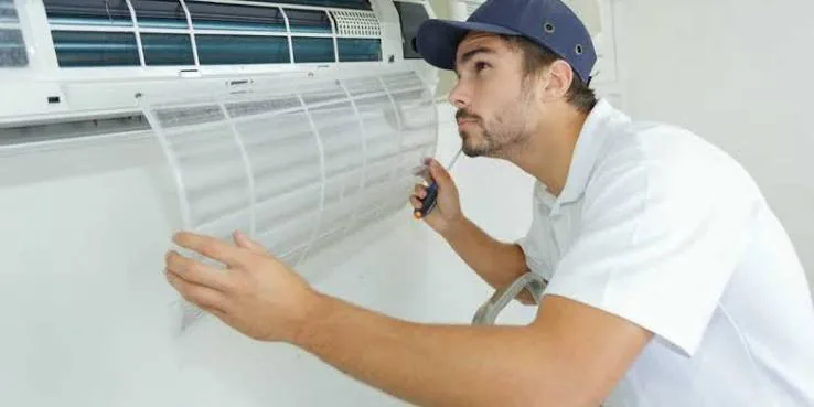 Indoor air conditioner filter being removed during routine maintenance