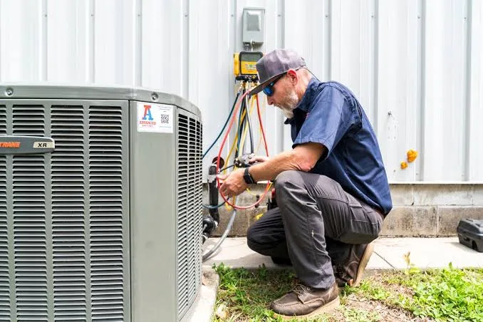 Outdoor air conditioner connected to diagnostic gauges during a service visit